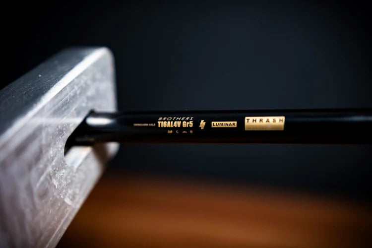 Close-up of the IZI Brothers Grade 5 titanium axle with laser etching for the Sur-Ron Light Bee swingarm.