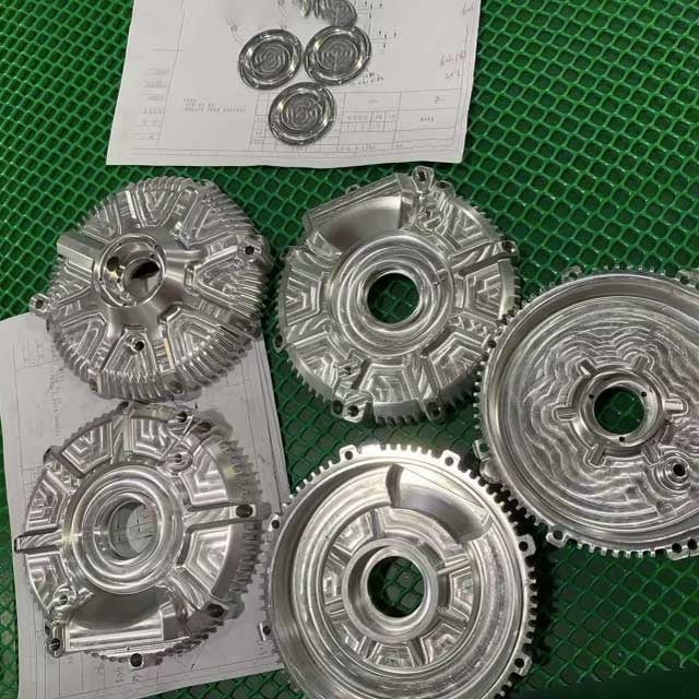 CNC-machined aluminum motor housings for the IZI Brothers Hornet electric motorcycle, showing precision cooling and gear cover details.