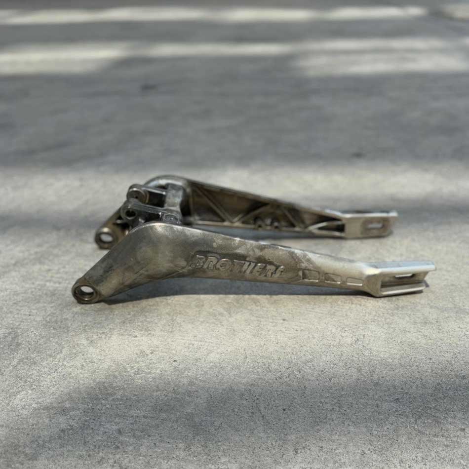 IZI Brothers Sur-Ron aluminum swingarm prototype showing raw cast structure before surface finishing.